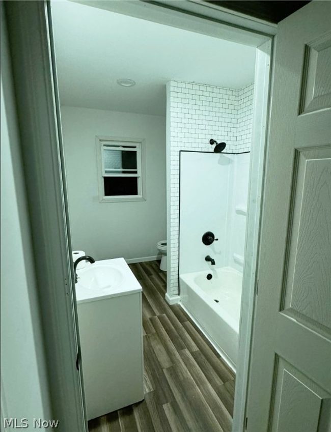 Full bathroom with shower / tub combination, hardwood / wood-style flooring, toilet, and vanity | Image 15