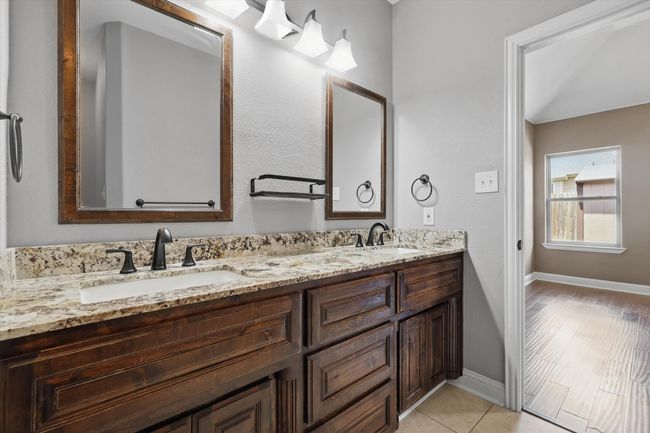 Bathroom with double vanity, baseboards, and tile patterned floors | Image 21