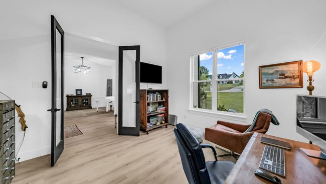 Office space featuring light wood finished floors, a chandelier, a high ceiling, and baseboards | Image 7