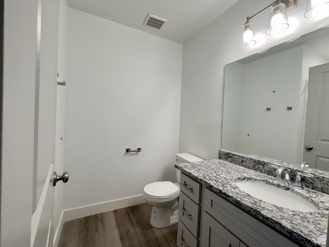 Bathroom featuring toilet, LVP flooring, and vanity and shower | Image 7