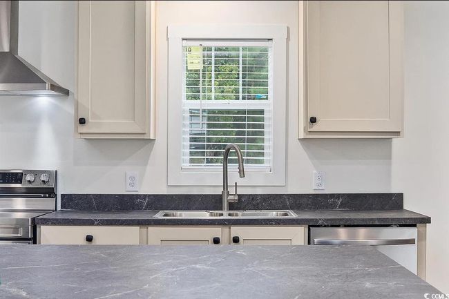 Kitchen with wall chimney range hood and stainless steel appliances | Image 6