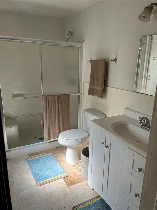 Bathroom featuring tile walls, toilet, tasteful backsplash, walk in shower, and vanity | Image 22