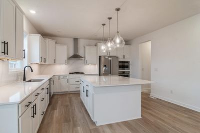 Photo is of the actual home. The Washburn offers a gourmet kitchen with Frigidaire professional appliances, quartz countertops, soft close cabinets, under cabinet lighting and walk in pantry. | Image 2