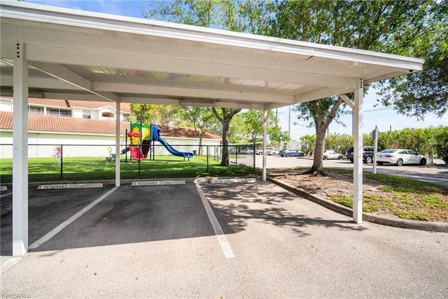 Partially covered parking lot with fence and playground community | Image 33