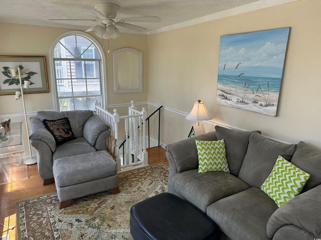 Living room with wood finished floors, a textured ceiling, and ceiling fan | Image 16