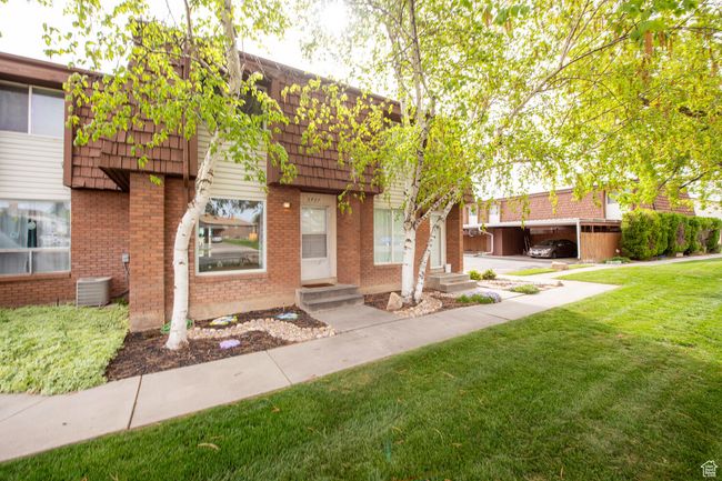 View of property with mansard roof, a front lawn, entry steps, and brick siding | Image 16
