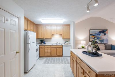 Kitchen with sink, light tile patterned flooring, a textured ceiling, and white appliances | Image 3