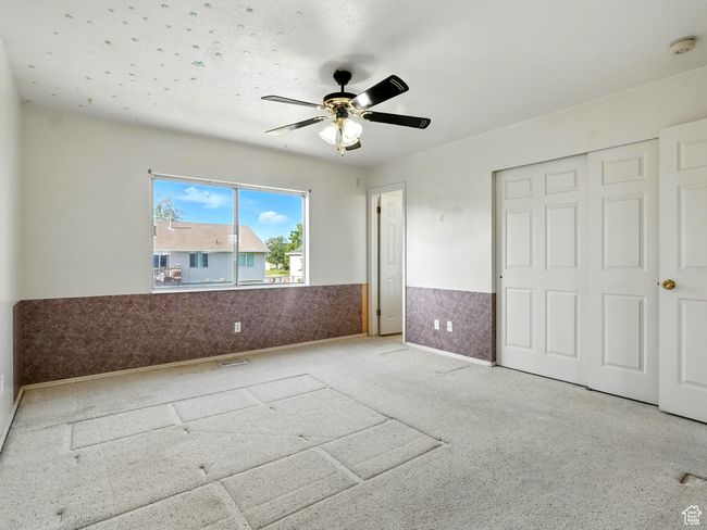 Unfurnished bedroom featuring a wainscoted wall, a ceiling fan, and a closet | Image 16