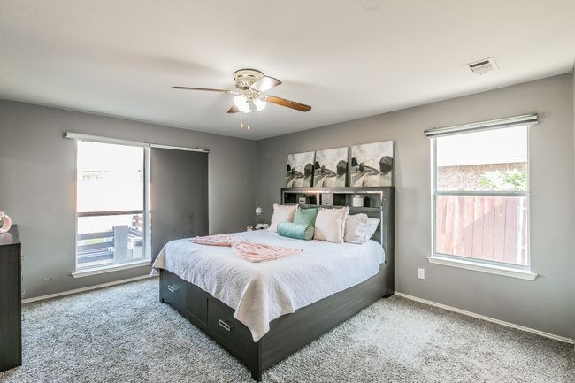 Bedroom with multiple windows, carpet floors, and a ceiling fan | Image 19