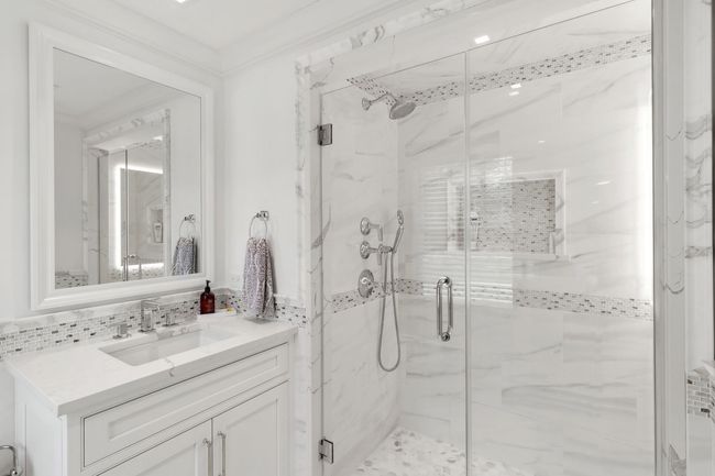 Bathroom with ornamental molding, vanity, a shower with shower door, and backsplash | Image 31