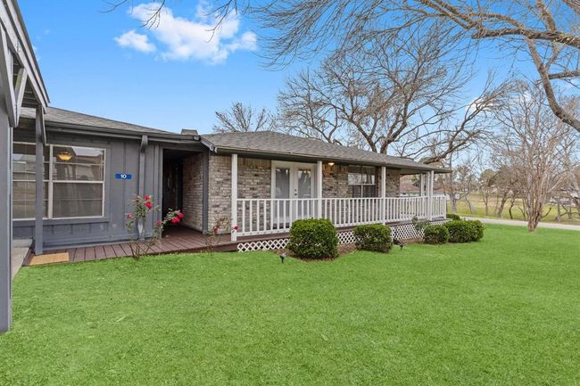 Charming single-story home with a stone facade, cozy front porch, and well-maintained lawn. | Image 37