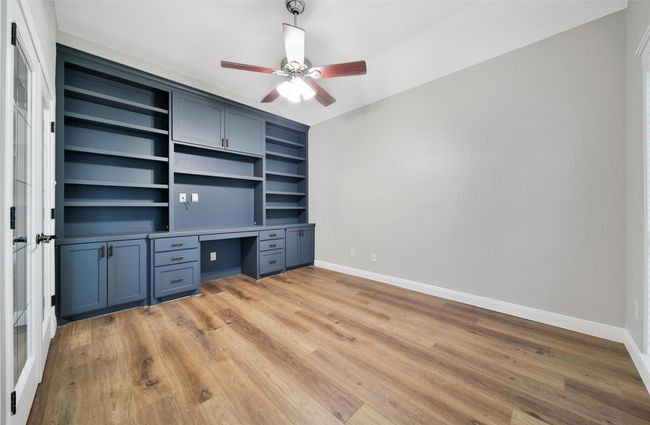 Large windows overlooking your small cul de sac and this fantastic floor to ceiling built-in make this the study to beat! There's tons of great storage and space for an additional workspace to create the ultimate home office. | Image 6
