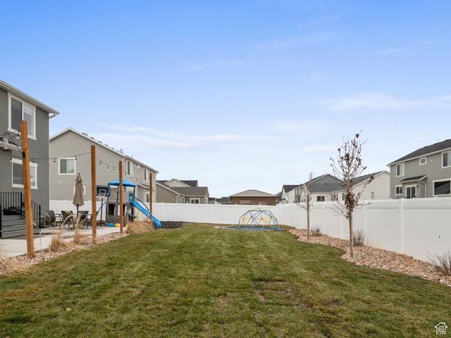 Fenced backyard with a playground, a residential view, and a patio | Image 10