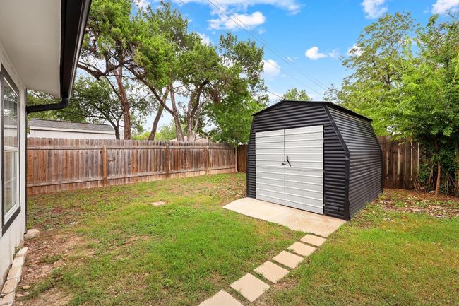 Fenced backyard with a storage unit | Image 27