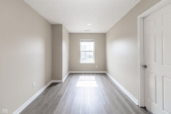 empty room with wood finished floors and a textured ceiling | Image 28