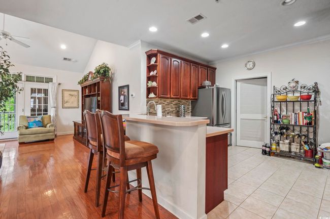 Kitchen with open shelves, light countertops, a breakfast bar area, a ceiling fan, and freestanding refrigerator | Image 17