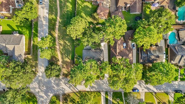 Cypresswood is a suburban neighborhood with tree-lined streets and well-maintained homes. The properties have spacious yards, and there's a nearby green space or park. The area appears peaceful and family-friendly, with a mix of single-story and multi-story houses. | Image 28