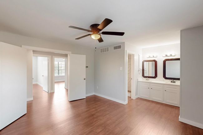 Unfurnished bedroom featuring a sink, visible vents, baseboards, and light wood-style floors | Image 22