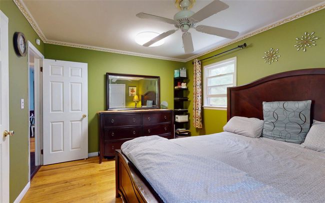 Bedroom with light wood-type flooring, crown molding, and ceiling fan | Image 31