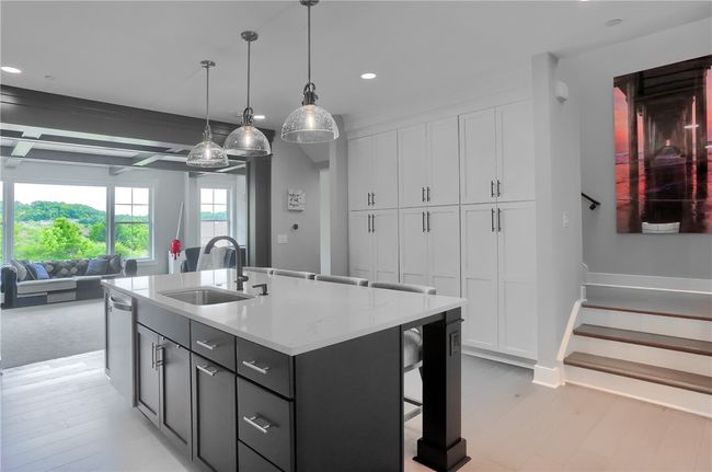 Designer pendant lighting, and a full wall of custom pantry cabinetry—all flowing seamlessly into a bright, open living space. | Image 9