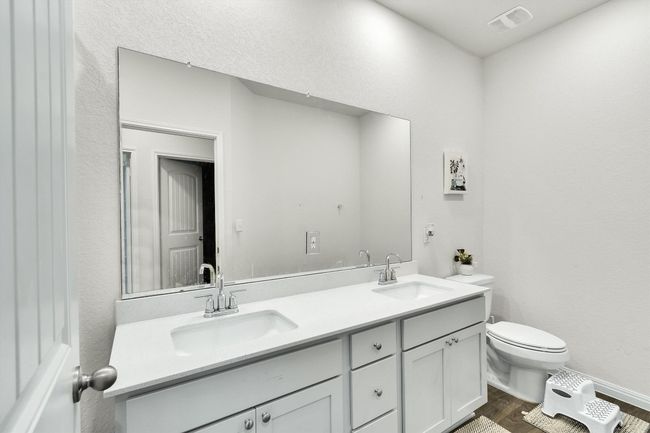 Bathroom featuring toilet, wood finished floors, and double vanity | Image 23