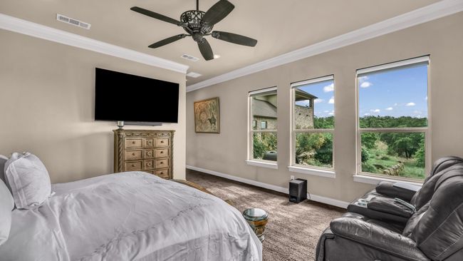 Carpeted bedroom featuring crown molding, baseboards, a ceiling fan, and visible vents | Image 23