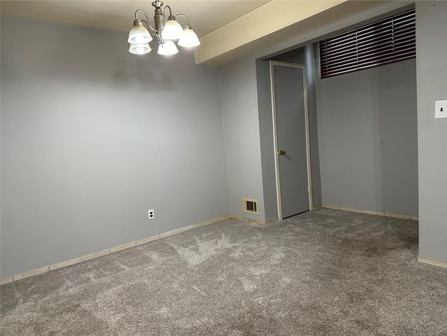 Carpeted empty room with visible vents, baseboards, and an inviting chandelier | Image 14
