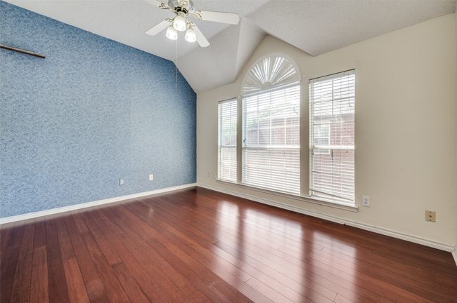 Unfurnished room with wood-type flooring, wallpapered walls, a ceiling fan, and baseboards | Image 25