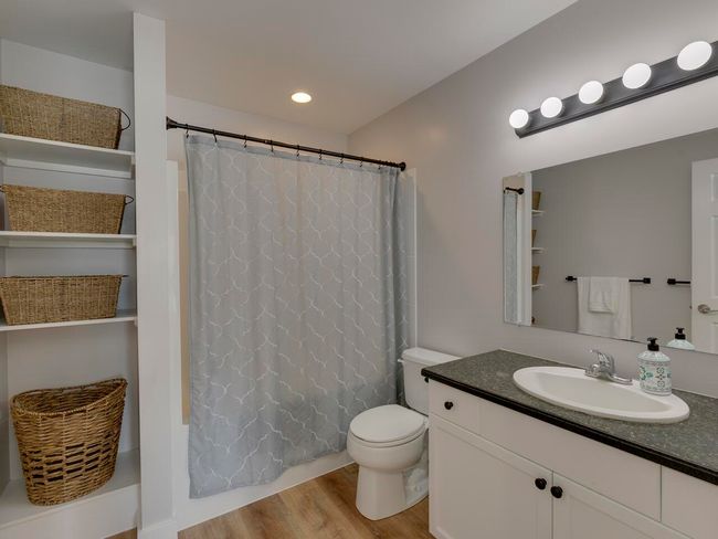 Full bath featuring toilet, recessed lighting, shower / tub combo, wood finished floors, and vanity | Image 23