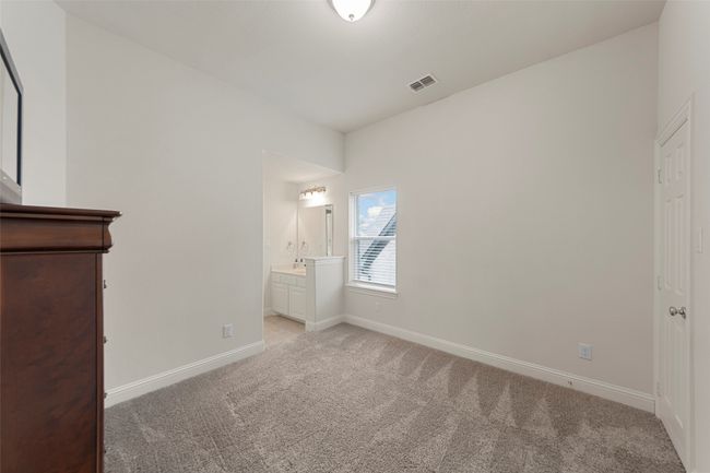 Unfurnished bedroom featuring light colored carpet, baseboards, ensuite bathroom, and a sink | Image 28