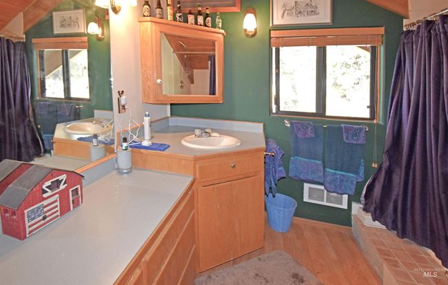 Bathroom with wood finished floors, vanity, lofted ceiling, and a shower with shower curtain | Image 17