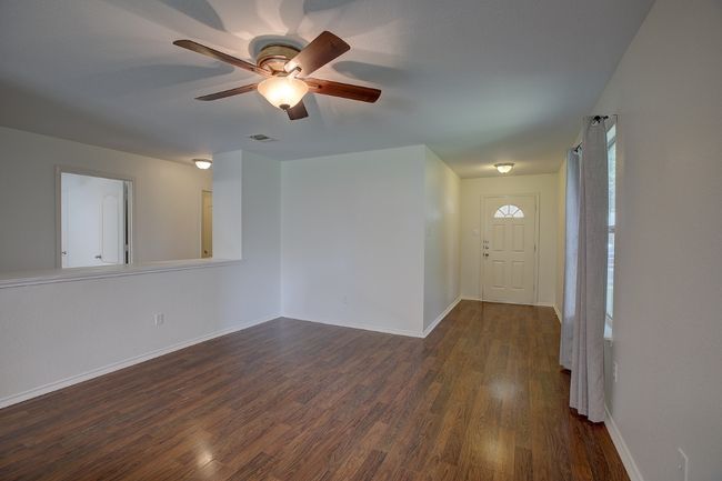 Nice family area featuring dark wood-type flooring, a ceiling fan, and baseboards | Image 13