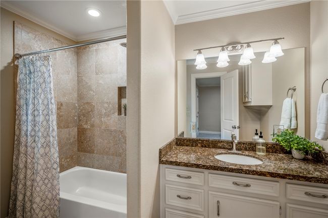 Bathroom featuring shower / bath combination with curtain, vanity, and crown molding | Image 25