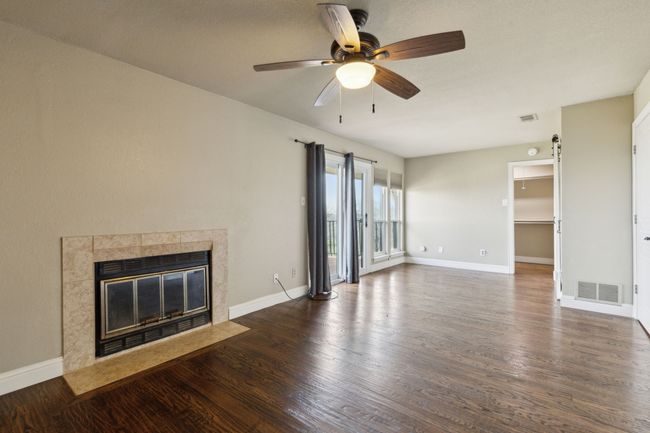 Unfurnished living room with visible vents, baseboards, dark wood finished floors, and a fireplace | Image 17