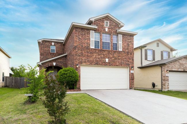 Traditional-style home featuring brick siding, driveway, and a garage | Image 13
