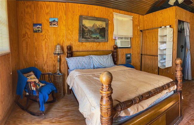 Bedroom featuring wooden walls, wood finished floors, and cooling unit | Image 33