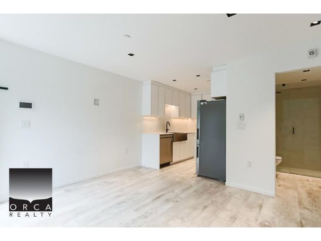 Unfurnished living room featuring light wood finished floors and baseboards | Image 12