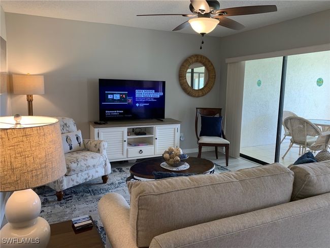 Living area featuring a ceiling fan and baseboards | Image 6