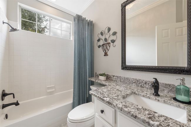 Bright and stylish full bath with granite vanity, updated fixtures, and a tub/shower combo. | Image 19
