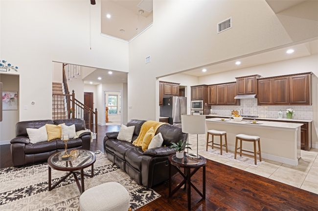 Living area with light wood-style floors, stairway, a towering ceiling, and recessed lighting | Image 12