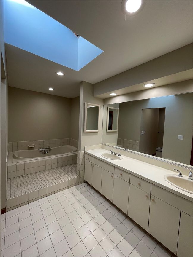 Full bathroom with double vanity, a garden tub, tile patterned floors, and a sink | Image 11