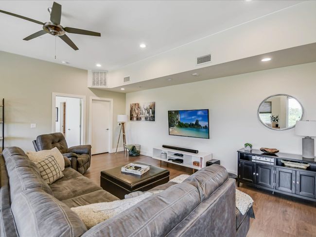 Living room with wood finished floors, ceiling fan, and recessed lighting | Image 7