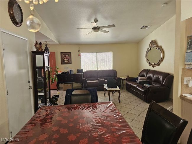 Living area with visible vents, ceiling fan, and light tile patterned flooring | Image 4
