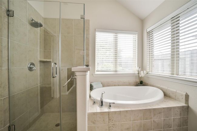 The huge soaking tub is the perfect place to relax and enjoy the sun and garden views. A framless shower enclosure gives a modern feel to the walk-in shower. | Image 17