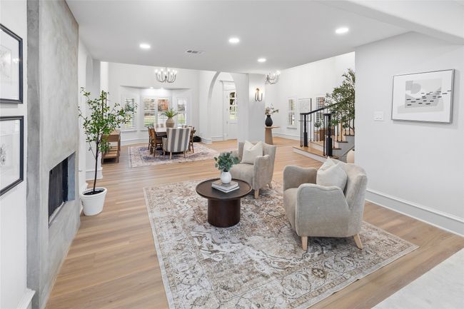Living area with light wood finished floors, a large fireplace, stairway, a chandelier, and recessed lighting | Image 19