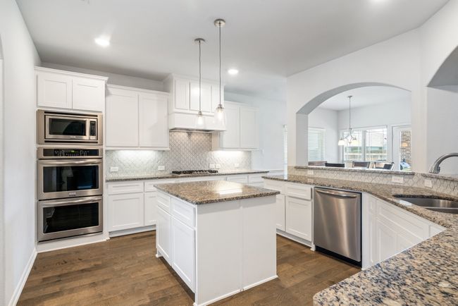 Kitchen with appliances with stainless steel finishes, arched walkways, tasteful backsplash, dark wood-style floors, and recessed lighting | Image 13