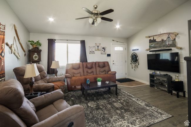 Living area with ceiling fan, baseboards, lofted ceiling, dark wood-style flooring, and recessed lighting | Image 6