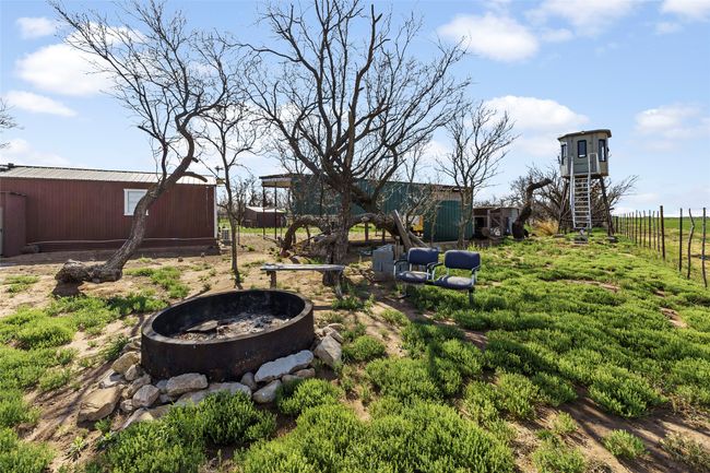 View of yard featuring an outbuilding, fence, and a fire pit | Image 20