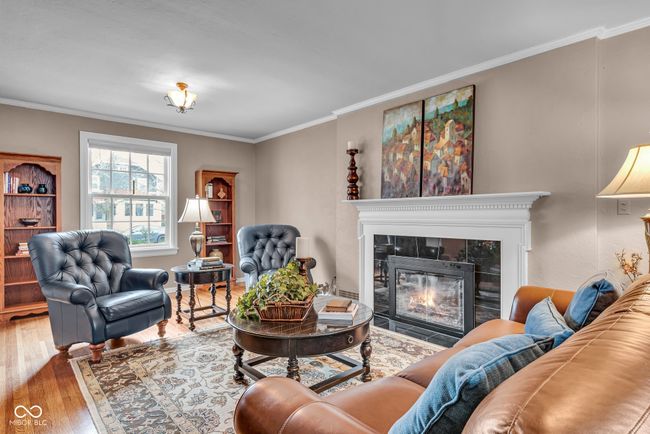 living area featuring ornamental molding, a tile fireplace, and hardwood / wood-style flooring | Image 7