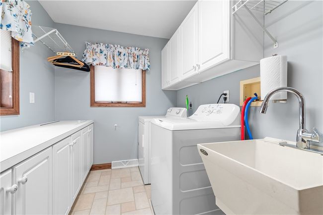 Main floorlaundry with cabinets, counter space and natural light | Image 18